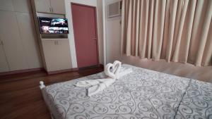 a room with a bed with two swans on it at 1775 Adriatico Suites in Manila