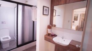 a bathroom with a sink and a mirror and a toilet at 1775 Adriatico Suites in Manila
