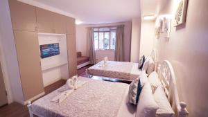 a hotel room with two beds and a tv at 1775 Adriatico Suites in Manila