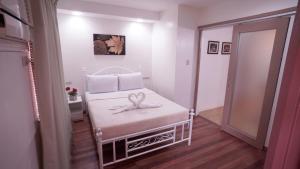 a small bedroom with a white bed with two towels on it at 1775 Adriatico Suites in Manila