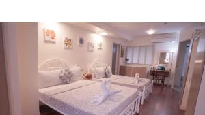a bedroom with two beds with white sheets at 1775 Adriatico Suites in Manila