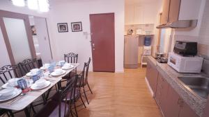 a kitchen with a long table with chairs and a microwave at 1775 Adriatico Suites in Manila