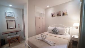 a bedroom with two beds with a towel animal on the bed at 1775 Adriatico Suites in Manila