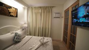a hotel room with a bed and a tv at 1775 Adriatico Suites in Manila