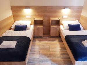 two beds in a room with wooden walls at Gościniec Piast Hotel i Camping in Brzeźno