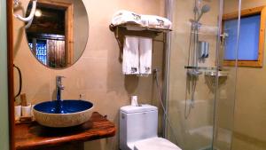 een badkamer met een wastafel, een toilet en een douche bij Lost World Sanjiang Guest house in Sanjiang