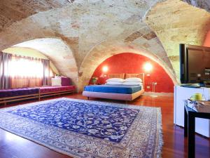 una camera con un letto in una stanza con un muro in pietra di Monteforte Resort a Ugento