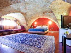 a bedroom with a bed in a room with a stone wall at Monteforte Resort in Ugento