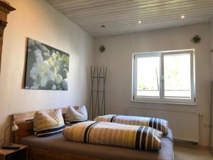 1 dormitorio con 1 cama con 2 almohadas y ventana en Ferienwohnungen In de goldisch Luft, en Gau-Algesheim