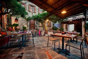 un patio avec tables et chaises dans un bâtiment dans l'établissement Archontiko Soulioti, à Ayiá