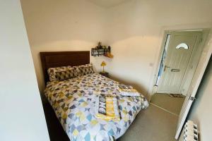 a bedroom with a bed with yellow pillows on it at Rosevale Apartment in Hawick