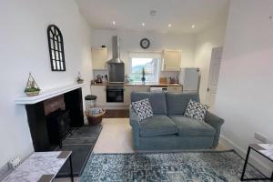 a living room with a couch and a fireplace at Rosevale Apartment in Hawick