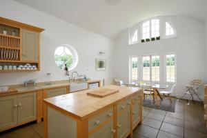 a kitchen with white walls and windows and a table at Eden at Broughton Sanctuary in Skipton