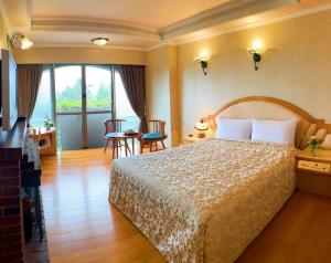 Habitación de hotel con cama, mesa y sillas en Kao Feng Hotel, en Zhongzheng