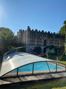 a swimming pool in front of a building at La Tuilerie 1860 in Biaudos