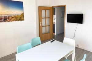 einen Tagungsraum mit einem Tisch und Stühlen sowie einem TV in der Unterkunft City-Apartment Halle mit TV und WLAN in Angersdorf