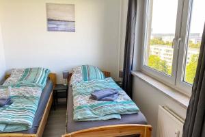 two beds in a room with a window at City-Apartment Halle mit TV und WLAN in Angersdorf