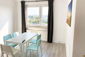 ein Esszimmer mit einem Tisch, Stühlen und einem Fenster in der Unterkunft City-Apartment Halle mit TV und WLAN in Angersdorf