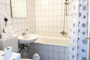 ein Badezimmer mit einem Waschbecken, einem WC und einer Badewanne in der Unterkunft City-Apartment Halle mit TV und WLAN in Angersdorf