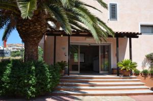 een palmboom voor een gebouw bij Hotel Delle Isole in La Maddalena