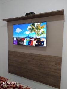 uma televisão de ecrã plano montada numa parede em Espaço Luanda - Ingleses Florianopolis em Florianópolis