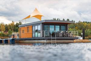 ein kleines Haus auf einer Anlegestelle am Wasser in der Unterkunft Floatinghouses Bärwalder See in Klitten