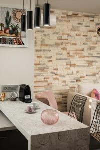 cocina con mesa con sillas y pared de piedra en YasMyr Villas, en Plataniás