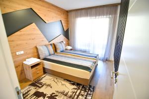 a small bedroom with a bed and a window at Mountain Wings Apartments in Bjelašnica