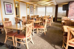 comedor con mesas y sillas de madera en Days Inn by Wyndham Rolla, en Rolla