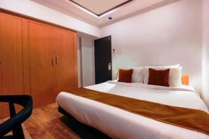 a bedroom with a large white bed and a wooden cabinet at Hotel Mallikarjuna Residency in Hyderabad