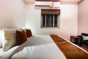 a bedroom with a large white bed with a window at Hotel Mallikarjuna Residency in Hyderabad