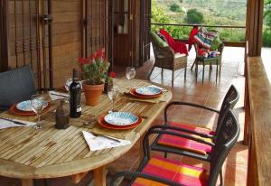 een houten tafel en stoelen op een patio bij Casa de Madera in Sedella
