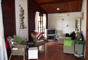 een woonkamer met een bank en een tv bij Casa de Madera in Sedella