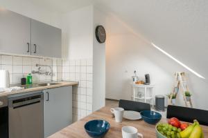 a kitchen with a wooden table with a bowl of fruit at CASSEL LOFTS - Komfortable Wohnung für 4 - nahe SMA & Fulda in Niestetal