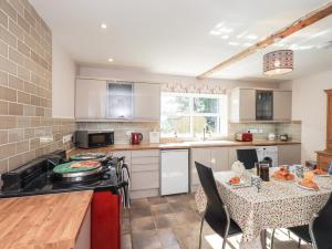 a kitchen with a table and a counter top at Allergarth Barn in Carlisle