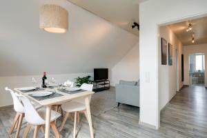 a dining room and living room with a table and chairs at CASSEL LOFTS - Komfortable Wohnung für 4 - nahe SMA & Fulda in Niestetal +14 photos