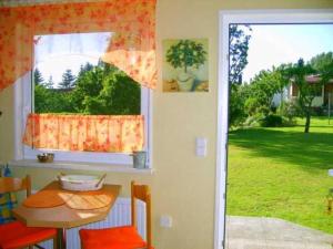 een keuken met een tafel en een raam en een tafel en stoelen bij Ferienhaus naehe Binz WE12899 in Seerams