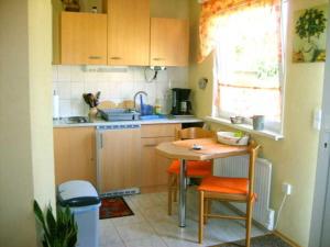 een kleine keuken met een tafel en stoelen. bij Ferienhaus naehe Binz WE12899 in Seerams