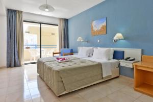 a bedroom with a large bed with a blue wall at Napa Prince Hotel Apts in Ayia Napa