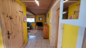 Ferienhaus Julchen Samtens في Samtens: ممر مع غرفة بجدران صفراء وباب