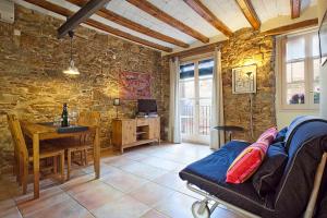 a living room with a table and a stone wall at Friendly Rentals Santa Monica in Barcelona