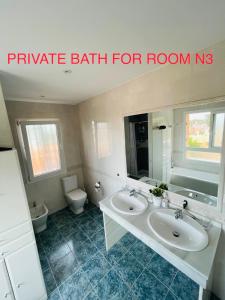 a bathroom with two sinks and a toilet at Marbella Deluxe Rooms in Royal Cabopino Townhouse in Marbella