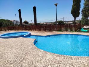 a swimming pool with blue water in a yard at Tu Casa Rural in Castilblanco de los Arroyos