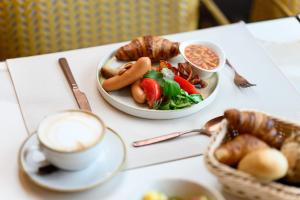 una mesa con dos platos de comida y una taza de café en Hotel Vision Budapest by Continental Group en Budapest