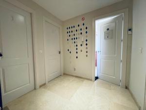 a hallway with two white doors and a wall with glasses at Marbella Deluxe Rooms in Royal Cabopino Townhouse in Marbella