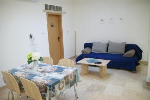a living room with a table and a blue couch at APARTMAN IVANA in Pula