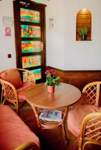 een tafel en stoelen en een tafel met bloemen erop bij B&B Casa Mica Guesthouse in Boekarest
