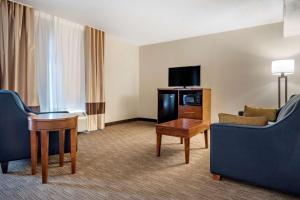 a hotel room with a couch and a table and a tv at Comfort Inn & Suites Oxford South in Oxford