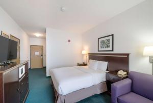 um quarto de hotel com uma cama e um sofá em Rodeway Inn Urbana Champaign University Area em Champaign