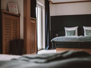 Schlafzimmer mit einem Bett und einem Fenster in der Unterkunft LEDA AM ECK in Bad Wiessee